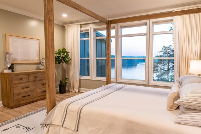 bedroom with ornamental molding and light hardwood / wood-style floors