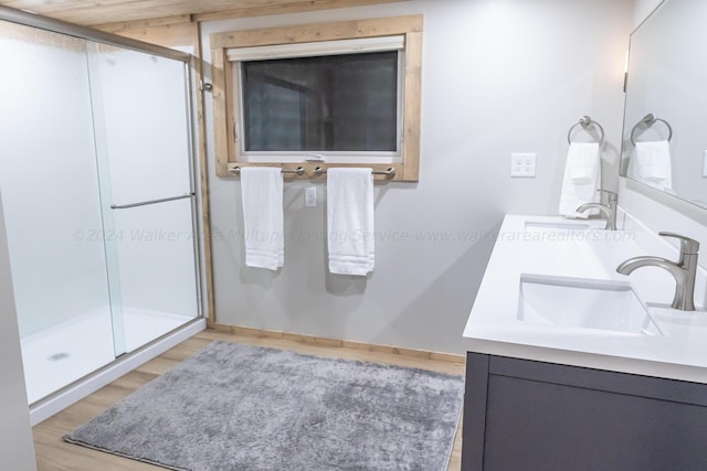 bathroom with a shower with shower door, hardwood / wood-style flooring, and vanity