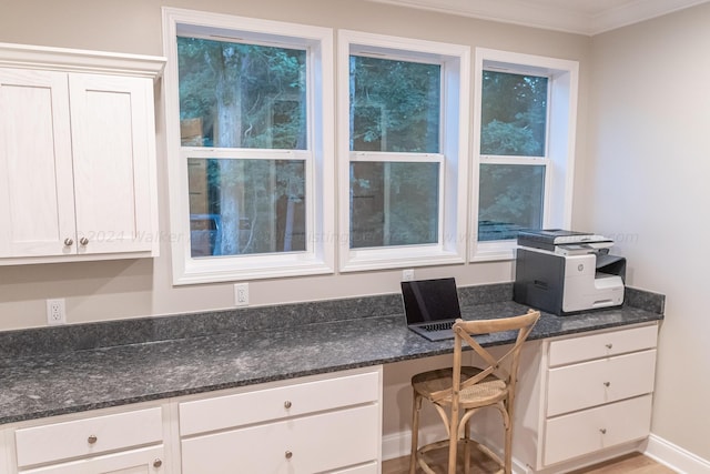 office space with built in desk, crown molding, and light hardwood / wood-style floors