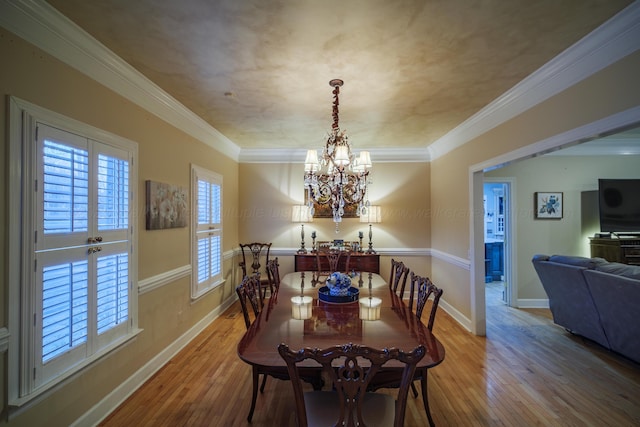 dining space featuring crown molding, a notable chandelier, and light wood-type flooring