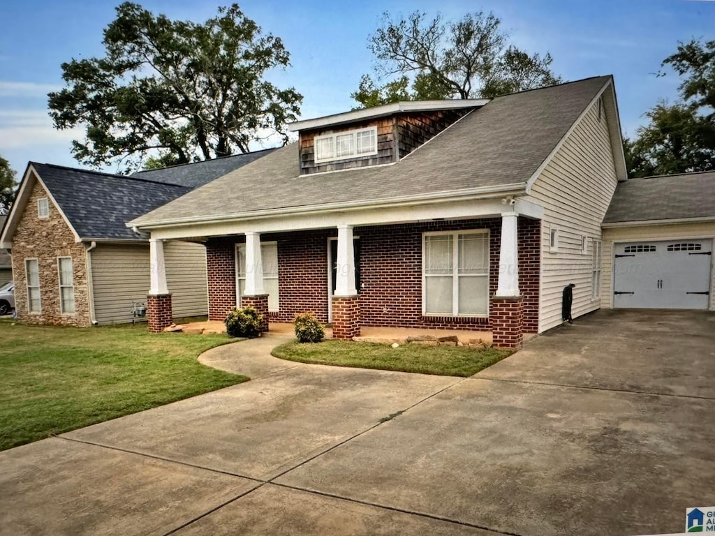 craftsman house featuring covered porch, a garage, and a front lawn