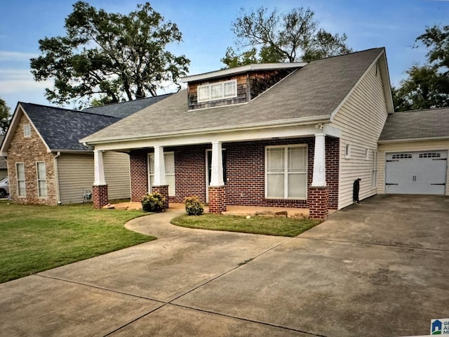 craftsman house featuring covered porch, a garage, and a front lawn