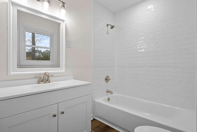 full bathroom with vanity, wood finished floors, and shower / bath combination