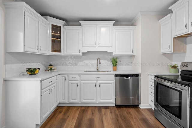 kitchen with appliances with stainless steel finishes, white cabinetry, light countertops, and a sink