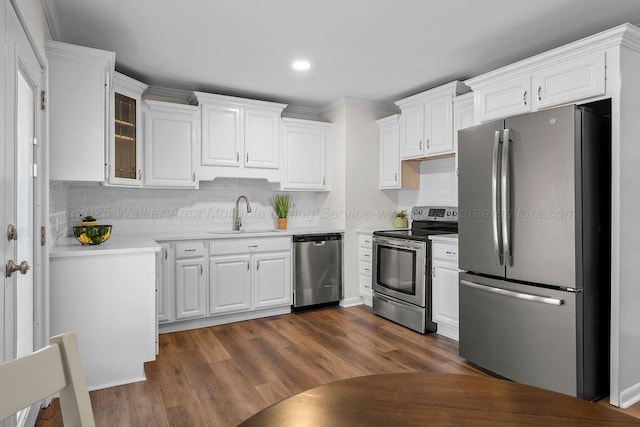 kitchen with dark wood finished floors, white cabinets, appliances with stainless steel finishes, and a sink