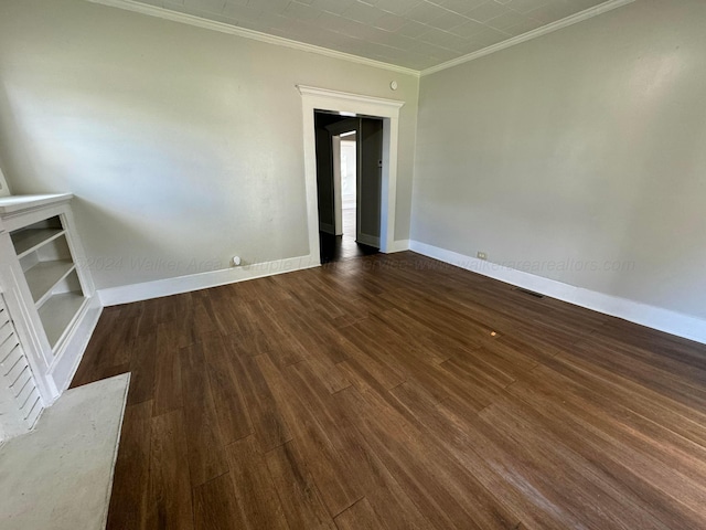 empty room with dark hardwood / wood-style flooring and ornamental molding