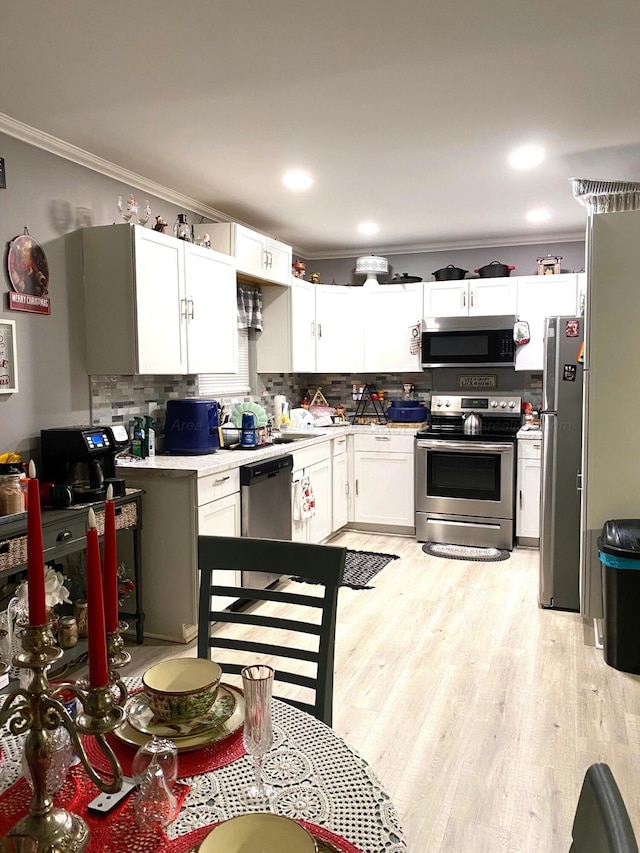 kitchen with backsplash, white cabinetry, dishwasher, and light hardwood / wood-style floors