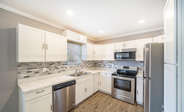 kitchen featuring white cabinetry, sink, ornamental molding, and appliances with stainless steel finishes