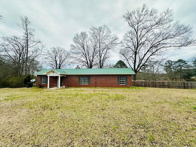 view of front of home with brick siding, a front yard, and fence