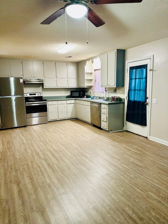 kitchen featuring under cabinet range hood, light wood-style flooring, stainless steel appliances, and light countertops