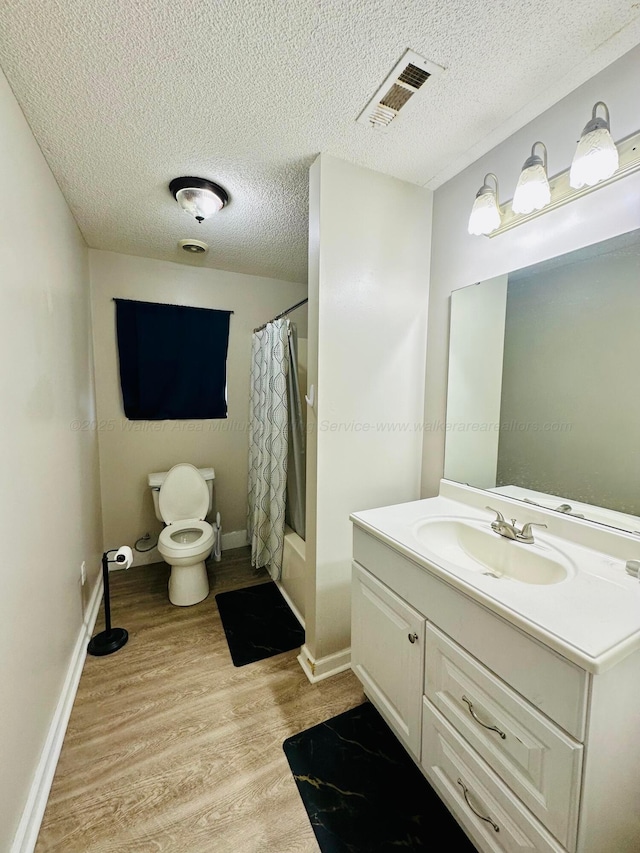 bathroom with visible vents, toilet, shower / tub combo, vanity, and wood finished floors