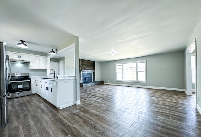 kitchen with open floor plan, appliances with stainless steel finishes, a sink, and white cabinets