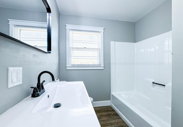 bathroom featuring wood finished floors, a sink, and baseboards