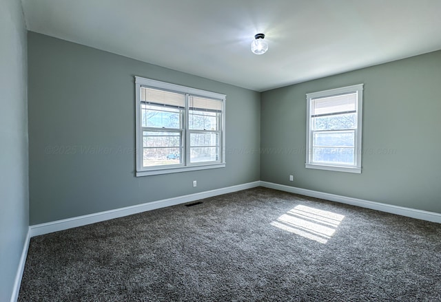 carpeted spare room with visible vents and baseboards