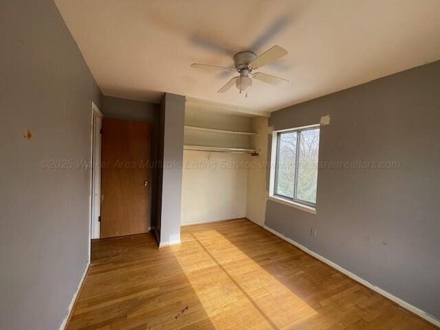 unfurnished bedroom featuring ceiling fan, light hardwood / wood-style flooring, and a closet