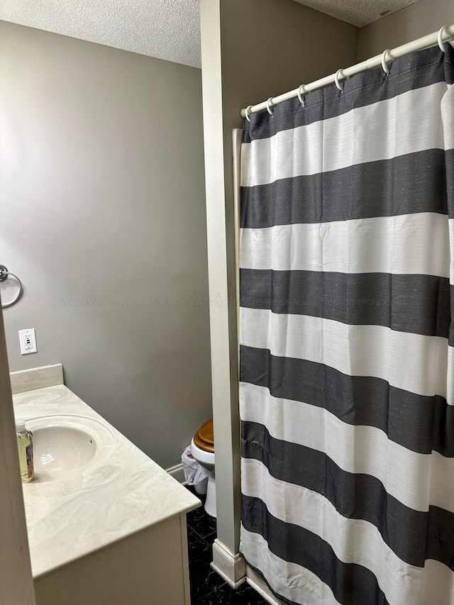 full bath featuring a textured ceiling, toilet, vanity, and a shower with curtain