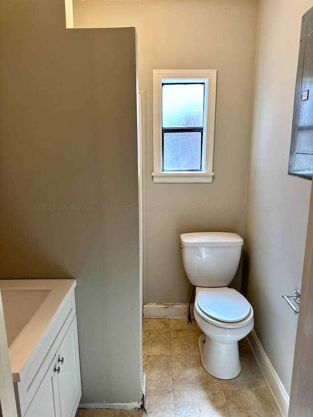 bathroom featuring toilet, tile patterned floors, baseboards, and vanity