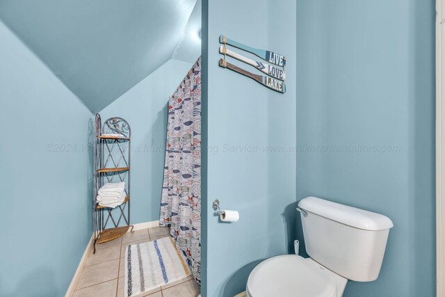 bathroom featuring toilet, tile patterned flooring, and vaulted ceiling