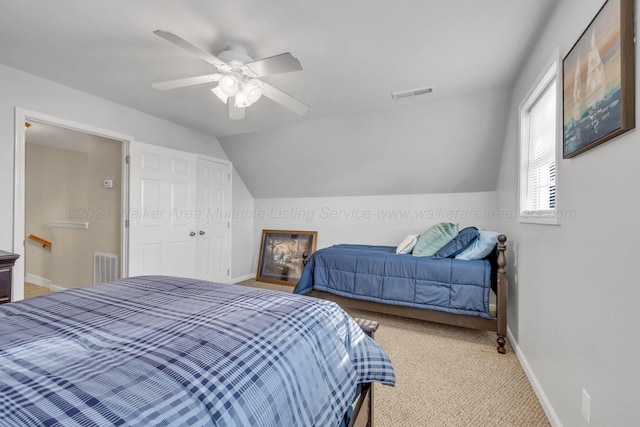 carpeted bedroom with a closet, vaulted ceiling, and ceiling fan