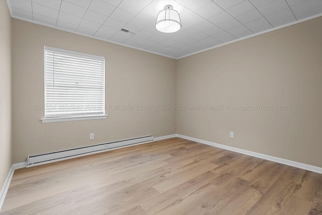 unfurnished room featuring ornamental molding, light hardwood / wood-style flooring, and a baseboard heating unit