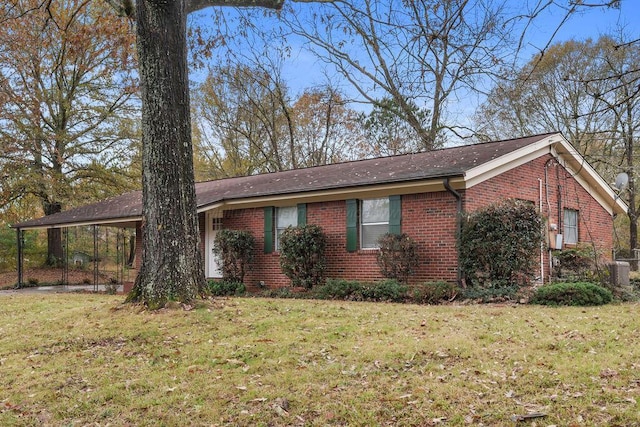 view of front of home with a carport, central AC unit, and a front yard