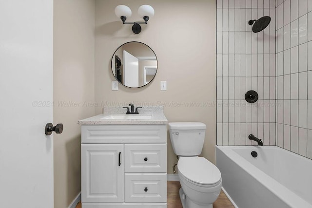 full bathroom with tiled shower / bath, vanity, and toilet