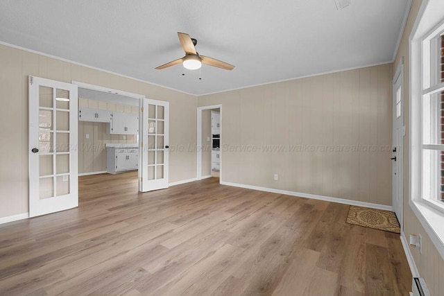 spare room with ornamental molding, french doors, a baseboard radiator, and light hardwood / wood-style flooring