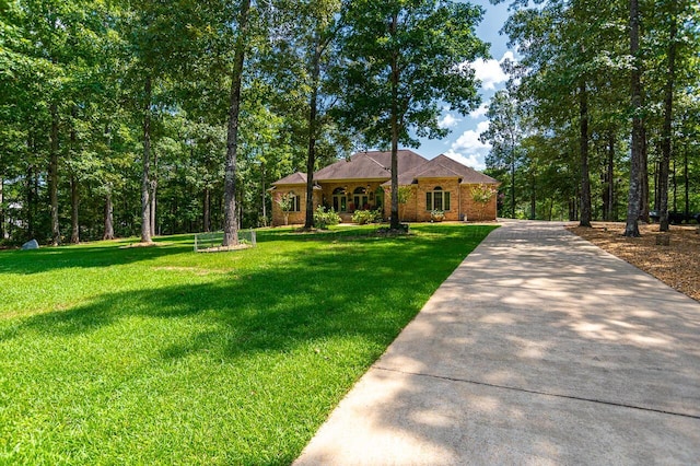 view of front of home featuring driveway, brick siding, and a front lawn