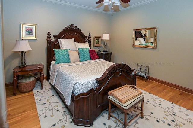 bedroom featuring a ceiling fan, baseboards, light wood-style floors, and crown molding