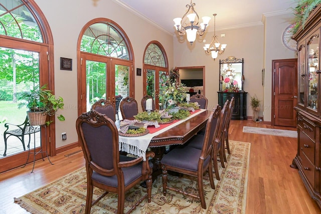 dining room featuring crown molding, light wood-style floors, and a healthy amount of sunlight