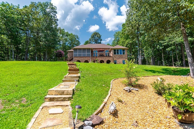 ranch-style home featuring a front lawn and brick siding