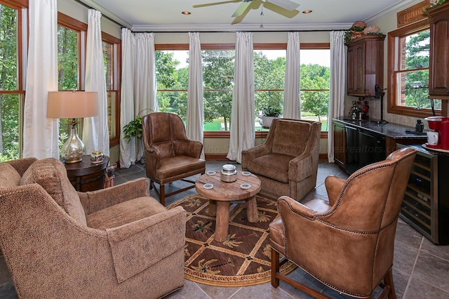 interior space featuring crown molding, beverage cooler, stone tile floors, recessed lighting, and a ceiling fan