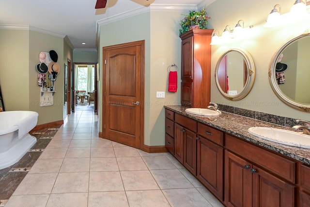 bathroom featuring tile patterned flooring, crown molding, baseboards, and a sink