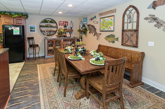 dining space featuring recessed lighting, baseboards, and a drop ceiling