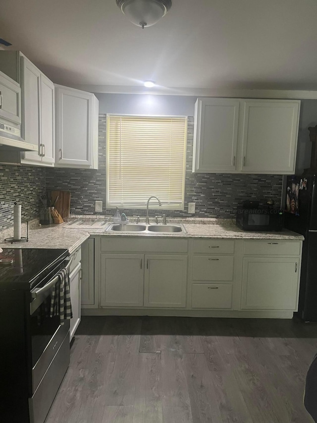 kitchen featuring tasteful backsplash, stainless steel range with electric stovetop, dark wood-type flooring, sink, and white cabinetry