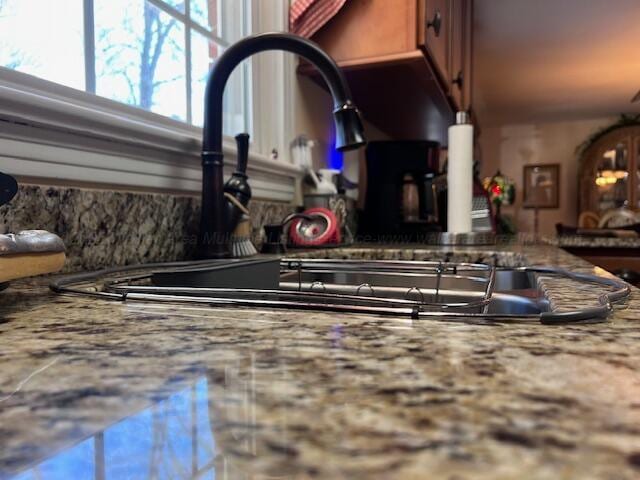 room details featuring stone countertops and a sink