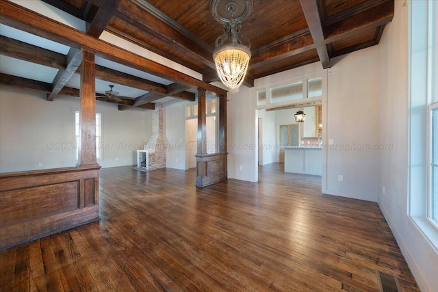 unfurnished living room featuring plenty of natural light, beamed ceiling, dark wood-type flooring, and ceiling fan with notable chandelier