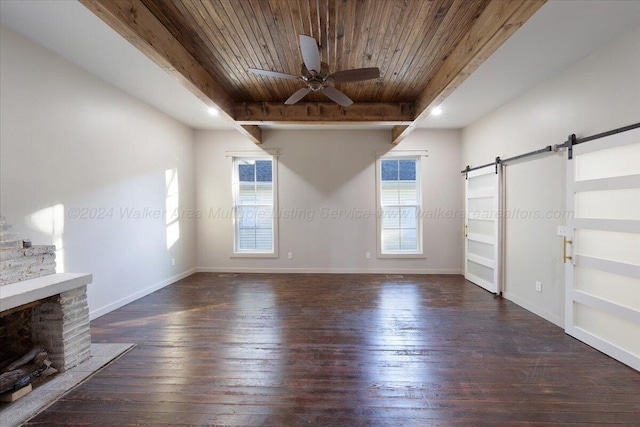 unfurnished living room with a barn door, ceiling fan, wood ceiling, and dark hardwood / wood-style floors