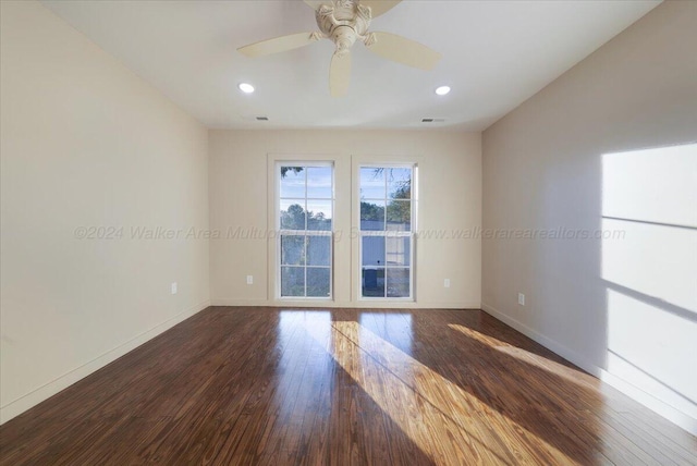 unfurnished room with ceiling fan and dark wood-type flooring