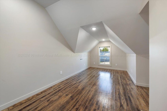 additional living space featuring vaulted ceiling and dark hardwood / wood-style floors