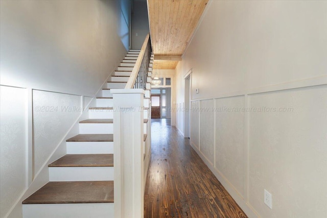 stairs featuring hardwood / wood-style floors and wood ceiling