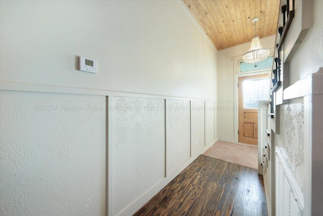 corridor with a chandelier, dark hardwood / wood-style floors, ornamental molding, and wood ceiling