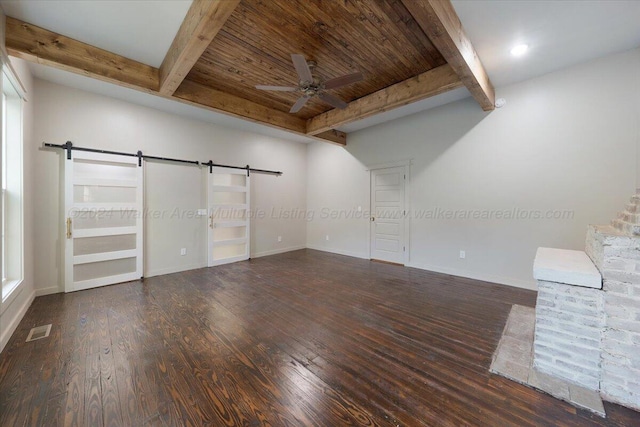 unfurnished living room featuring beam ceiling, dark hardwood / wood-style flooring, a barn door, and ceiling fan