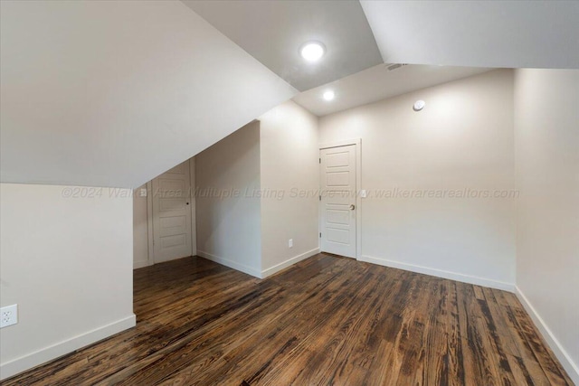 additional living space with dark hardwood / wood-style flooring and lofted ceiling