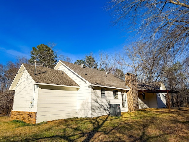 back of house featuring central air condition unit and a lawn