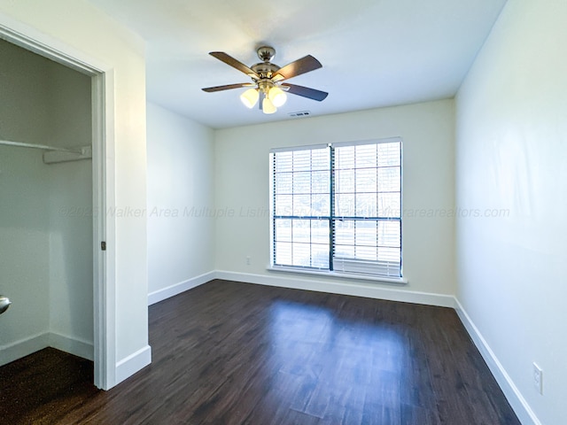 unfurnished bedroom featuring a closet, dark hardwood / wood-style floors, and ceiling fan