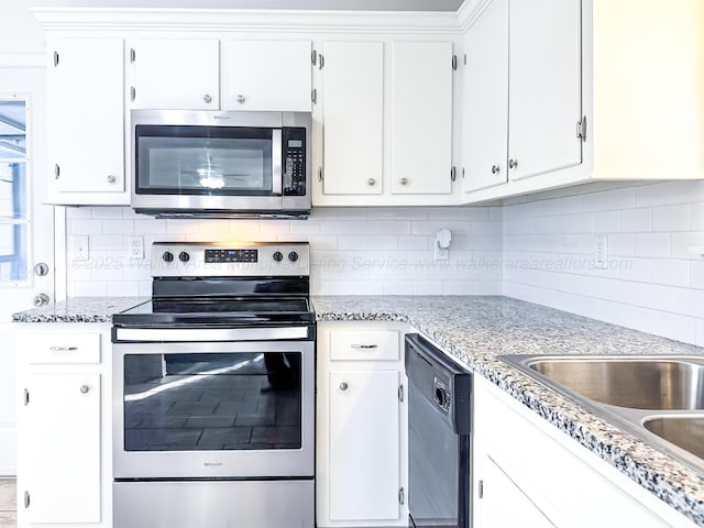 kitchen with appliances with stainless steel finishes, decorative backsplash, light stone countertops, and white cabinets