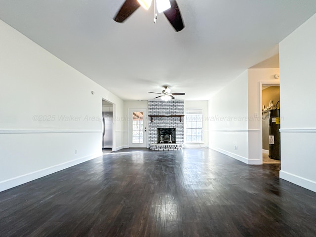 unfurnished living room with a fireplace, dark wood-type flooring, electric water heater, and ceiling fan