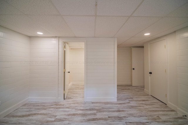 interior space with a drop ceiling and light hardwood / wood-style floors