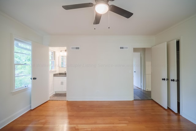 unfurnished room with ceiling fan, plenty of natural light, light hardwood / wood-style floors, and ornamental molding